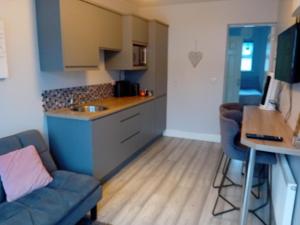 a kitchen and a living room with a couch and a table at Compact one bed apartment near University of Limerick in Gilloge Bridge