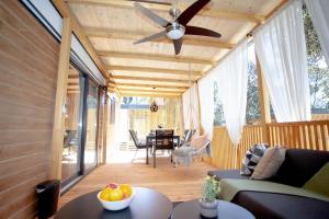 a living room with a ceiling fan and a table at Mobile Home Ivana in Biograd na Moru