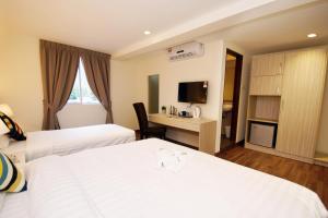 a hotel room with two beds and a desk at Good Luck Inn in Ayer Itam +17 photos