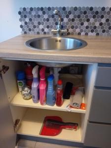 a bathroom vanity with a sink and bottles under it at Compact one bed apartment near University of Limerick in Gilloge Bridge