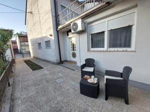 a patio with two chairs and a table in front of a building at Kia Ora in Bihać