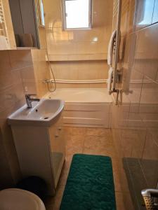 uma casa de banho com uma banheira, um lavatório e um chuveiro em Cazare Apartament Mangalia em Mangalia