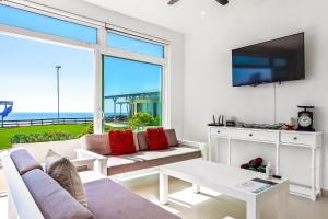 uma sala de estar com um sofá e uma televisão em Villa San Valentin 48 - Playa Arcangel em Rosarito