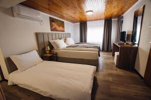 a hotel room with two beds and a television at Urban Studio Apartments in Strumica