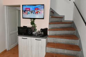 a tv hanging on a wall next to a staircase at Casa Marconi in Acquapendente