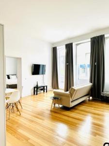 uma sala de estar com um sofá e um piso de madeira em 8 VILLAS Hotel em Santo Tirso