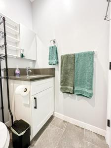 y baño con lavabo y toallas verdes. en Spacious 4BR-4BA in Hollywood-FUL2-WW, en Los Ángeles