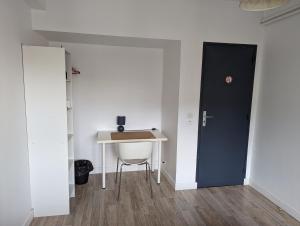 a room with a desk and a door and a table at Belle chambre exposée Sud in Le Havre