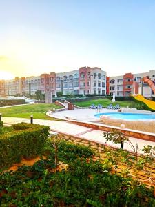 a large apartment complex with a large swimming pool at Oyster Bay Beach Suites in Abu Dabbab