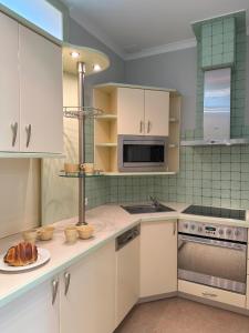 a kitchen with white cabinets and a plate of food on a counter at Apartamenty Pod Dzwonkiem in Wadowice