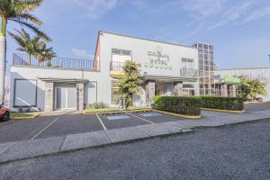 un edificio bianco con un parcheggio di fronte di Hotel Caña Brava Inn a Cañas