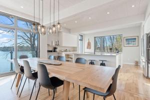cocina y comedor con mesa de madera y sillas en Stillness on the Shore - Fabulous family cottage en Parry Sound