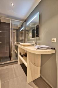 uma casa de banho com um balcão com um lavatório e um chuveiro em Résidence Grenier De Koikoi - Chalets pour 10 Personnes 404 em Notre-Dame-de-Bellecombe