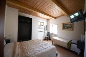 a bedroom with a bed and a flat screen tv at Affittacamere Casa Galiè in Comunanza