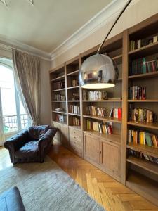 a living room with book shelves and a couch and a pendant light at Eleganza Liberty a due passi da Porta Susa e Metró in Turin