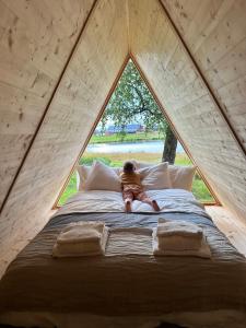 a child laying on a bed in a tent at Boutiquehotell Dahlbogården in Alingsås