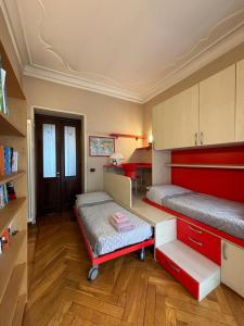 a bedroom with two beds and a red and white bed frame at Eleganza Liberty a due passi da Porta Susa e Metró in Turin