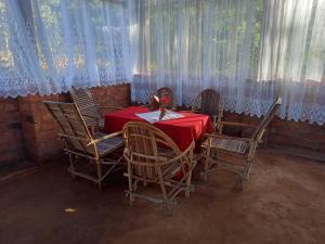 uma sala de jantar com uma mesa e quatro cadeiras em Irente Kinyonga Cottage em Lushoto
