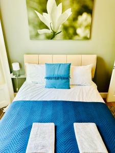 a blue and white bed with two pillows on it at Elegant 2 Bedroom Apartment in Central London in London
