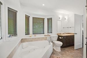 a white bathroom with a tub and a toilet at Todholm Muskoka in Port Carling