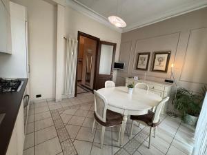 a kitchen with a white table and chairs in a room at Eleganza Liberty a due passi da Porta Susa e Metró in Turin