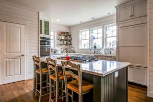 a kitchen with a large island with bar stools at Modern Gearhart Getaway, Walk to Beach and Downtown! in Gearhart