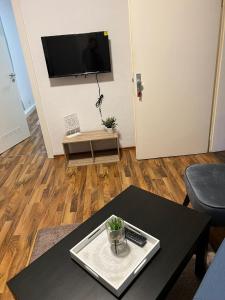 a living room with a table and a tv on a wall at Stadtnahen Wohnung I Küche I Oelde in Oelde