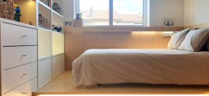 a small bedroom with a bed and a window at IH Apartments & Studios in Espinho
