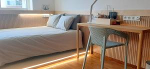 a bedroom with a bed and a desk with a chair at IH Apartments & Studios in Espinho