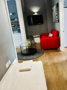 a living room with a red couch and a table at Elegant 2 Bedroom Apartment in Central London in London
