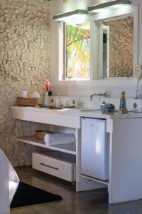 a white bathroom with a sink and a mirror at Canto do Sol Praia in Marau