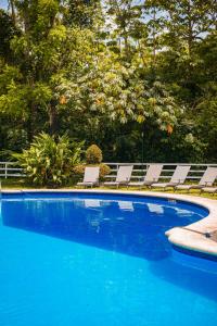 a swimming pool with lounge chairs and a swimming pool at Hotel Nututun Palenque in Palenque
