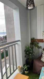 un balcone con piante in vaso e una luce a ciondolo di Seawind Condo - Sea View Samal Island View Gene Vacation Homes a Davao