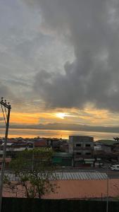 - une vue sur une ville avec le coucher du soleil en arrière-plan dans l'établissement Seawind Condo - Sea View Samal Island View Gene Vacation Homes, à Davao