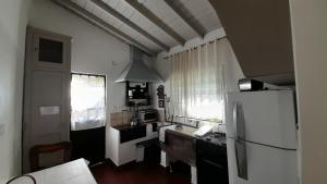 Casa de Huéspedes Muñiz sobre parque de 1000m2, 1 dormitorio, 20m2 cubiertos, baño con ducha, pileta cilíndrica de 3x076 في Muñiz: مطبخ مع ثلاجة وطاولة عمل