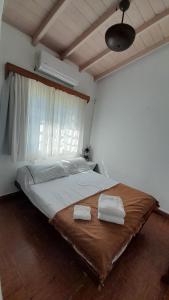 a bedroom with a large bed with two towels on it at Casa de Huéspedes Muñiz sobre parque de 1000m2, 1 dormitorio, 20m2 cubiertos, baño con ducha, pileta cilíndrica de 3x076 in Muñiz
