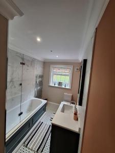 ein Badezimmer mit einer Badewanne und einem Waschbecken in der Unterkunft Tamlaught house in Glenariff