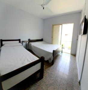 two beds in a room with a window at HOTEL RESIDENCIAL CAMACHO in Cordoba