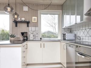 Holiday home Ørsted V في Ørsted: مطبخ مع دواليب بيضاء ونافذة