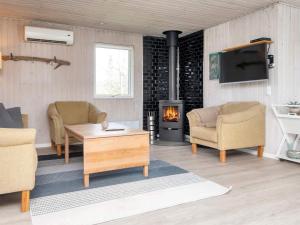 a living room with two chairs and a fireplace at Holiday home Ørsted V in Ørsted