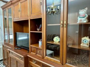 un gran armario de madera con TV. en Apartment in the heart of the Camino de Santiago en Sarria