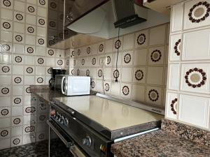 y cocina con fogones y microondas. en Apartment in the heart of the Camino de Santiago en Sarria