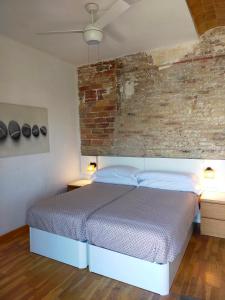 1 dormitorio con cama y pared de ladrillo en Barceloneta Port Ramblas, en Barcelona