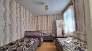 1 dormitorio con 2 camas individuales y ventana en Guest House "SVANETI" en Lentekhi