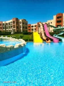 uma grande piscina com escorrega aquático em Oyster Bay Beach Suites em Abu Dabbab