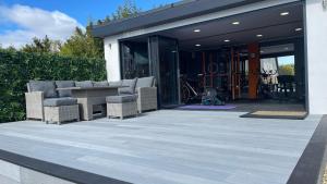 a patio with chairs and a table in front of a building at Private Luxury By The Sea, With A Personal Gym, Hot Tub, And Free Parking! in Hamworthy