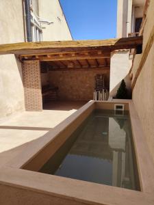 una piscina en un patio con terraza de madera en Casa de Agustín, en Valverde del Majano