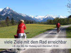 twee mensen die fietsen over een onverharde weg bij Biohof Burger, 3 sonnige Fewo, alle mit Balkon, Spielzimmer, Grillhütte, 7 km vor Oberstdorf in Bolsterlang