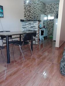 ein leeres Zimmer mit einem Tisch und Stühlen auf einem Holzboden in der Unterkunft Apartamento Mobiliado - Wi-Fi in Boa Vista