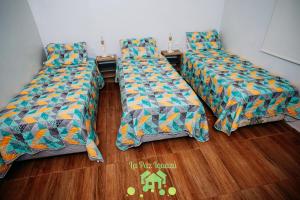 three beds sitting on a wooden floor in a room at La Paz Iguazú in Puerto Iguazú